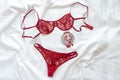 Shopping and fashion concept. Set of glamorous stylish lace lingerie on bed with flowers and wineglass on white background. F