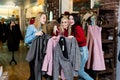 Shopping, fashion and friendship-three smiling friends choose a business suit in a clothing store and pose for the