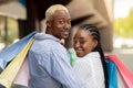 Shopping, fashion and fun time. Portrait of african american lovely couple holding colored shopping bags Royalty Free Stock Photo