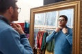 Man looking at mirror at vintage clothing store