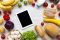 Shopping groceries concept. Composition of various healthy food with tablet on white wooden table. Cooking food background. Flat l Royalty Free Stock Photo