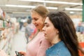 Shopping at the grocery store. Two young women choose products in the store. In the background, the trading floor of the store Royalty Free Stock Photo