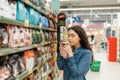 Shopping at the grocery store. A young brunette woman chooses a product by sniffing the fragrance through the packaging