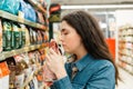 Shopping at the grocery store. A young brunette woman chooses a product by sniffing the fragrance through the packaging. Close up