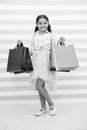 Shopping is her favorite activity. Child girl carries shopping bags striped bacground. In all ages women adore shopping Royalty Free Stock Photo