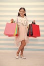 Shopping is her favorite activity. Child girl carries shopping bags striped bacground. In all ages women adore shopping Royalty Free Stock Photo