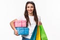 Shopping, holidays and lifestyle concept. Portrait of happy pretty young woman buying presents, holding wrapped boxed