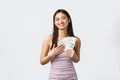 Shopping, holidays and people emotions concept. Greedy satisfied and happy smiling asian woman in evening dress, hugging