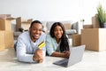 Shopping for household goods online concept. Happy black family buying stuff for their new house, using laptop Royalty Free Stock Photo