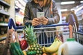 Shopping lists just got smarter. a woman using a mobile phone in a grocery store. Royalty Free Stock Photo