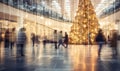 A shopping mall decorated for christmas with a large illuminated Christmas tree and busy shoppers Royalty Free Stock Photo