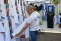 Shopping. Man customer choosing shirt at Ukrainian national embroidery street stall. Kyiv, Ukraine