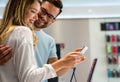 Shopping a new digital device. Happy couple buying a smartphone in store. Royalty Free Stock Photo
