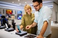 Shopping a new digital device. Happy couple buying a smartphone in store. Royalty Free Stock Photo