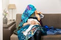 Shopping obsessed woman sitting on couch with clothes heap on her