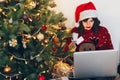 shopping online and christmas sale concept. stylish woman in reindeer hat holding credit card and laptop, under christmas tree li Royalty Free Stock Photo