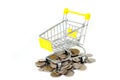 Empty yellow mini shopping cart or supermarket trolley with pile of silver money coins. Royalty Free Stock Photo