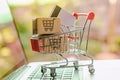 Shopping online concept - Parcel or Paper cartons with a shopping cart logo and credit card in a trolley on a laptop keyboard.