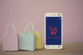 Shopping Online and e-commerce concept: paper shopping bags with smartphone on table. Online stores are considered as another Royalty Free Stock Photo