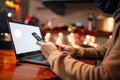 Shopping and online payment using cellphone, laptop and credit card. Man wearing mask during pandemic quarantine sits in a cafe Royalty Free Stock Photo