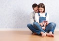 Shopping online together. Beautiful young loving couple shopping online while sitting on the floor together