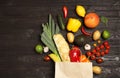 Shopping paper bag with  groceries on dark wooden background, flat lay Royalty Free Stock Photo