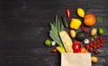 Shopping paper bag with  groceries on dark wooden background, flat lay. Space for text Royalty Free Stock Photo