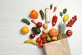 Shopping paper bag with different groceries on white wooden background Royalty Free Stock Photo