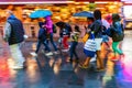 Shopping people in the rainy city at night