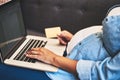 Shopping for the perfect baby crib comfortably from home. a pregnant woman using a laptop and credit card on the sofa at Royalty Free Stock Photo