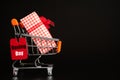 Shopping concept with red ticket Boxing day Sale tag hanging on shopping cart with gift box Royalty Free Stock Photo