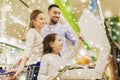 Family weighing oranges on scale at grocery store Royalty Free Stock Photo