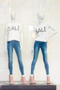 Shopping sale window display with mannequins wearing t-shirts with text Sale. Dummies in the store. Sale and fashion Royalty Free Stock Photo