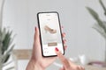 Shopping shoes online with e-commerce app concept. Woman holding smart phone and touch shop now button Royalty Free Stock Photo