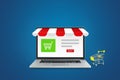 Shopping shop store  on laptop screen with shopping cart put on nearly the laptop. Royalty Free Stock Photo