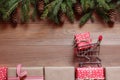 The shopping small cart with a gift on Christmas gifts on a wooden background