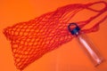 Shopping string bag with reusable bottle on orange background. zero waste concept