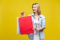 Shopping time! Portrait of satisfied shop customer rejoicing discount. indoor studio shot  on yellow background Royalty Free Stock Photo