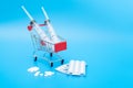 Shopping trolley with American and European banknotes and medical syringes Royalty Free Stock Photo