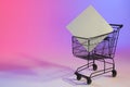 Shopping trolley with blank canvas and copy space over neon purple background