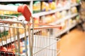 Shopping trolley cart with shallow DOF against supermarket aisle background Royalty Free Stock Photo