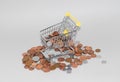 Shopping trolley cart surrounded by loose change, british penny coins. Overspending and cost of living concept