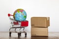 Shopping Trolley with carton and earth globe. International shopping and global logistics concept Royalty Free Stock Photo