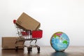 Shopping Trolley with carton and earth globe. Worldwide shopping and delivery business concept Royalty Free Stock Photo