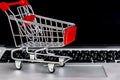 Shopping trolley on computer notebook with copay space Royalty Free Stock Photo