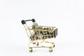 Shopping trolley with different coins isolated on white background. Royalty Free Stock Photo