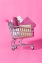 Shopping trolley full of wrapped gifts on pink background Royalty Free Stock Photo