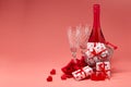 Shopping trolley, gift boxes, red roses and hearts, champagne and flutes on pink background with copy space. Valentine`s Day Royalty Free Stock Photo