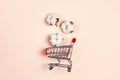 Shopping trolley with ÃÂotton plant flower on pink background