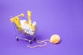 shopping trolley with various accessories and accessories for sewing, yellow threads of different colors, cord, ball of thread on Royalty Free Stock Photo